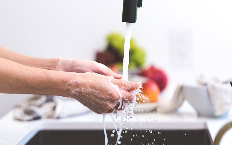 Küchenplatte mit Wasserhahn und gewaschenen Händen